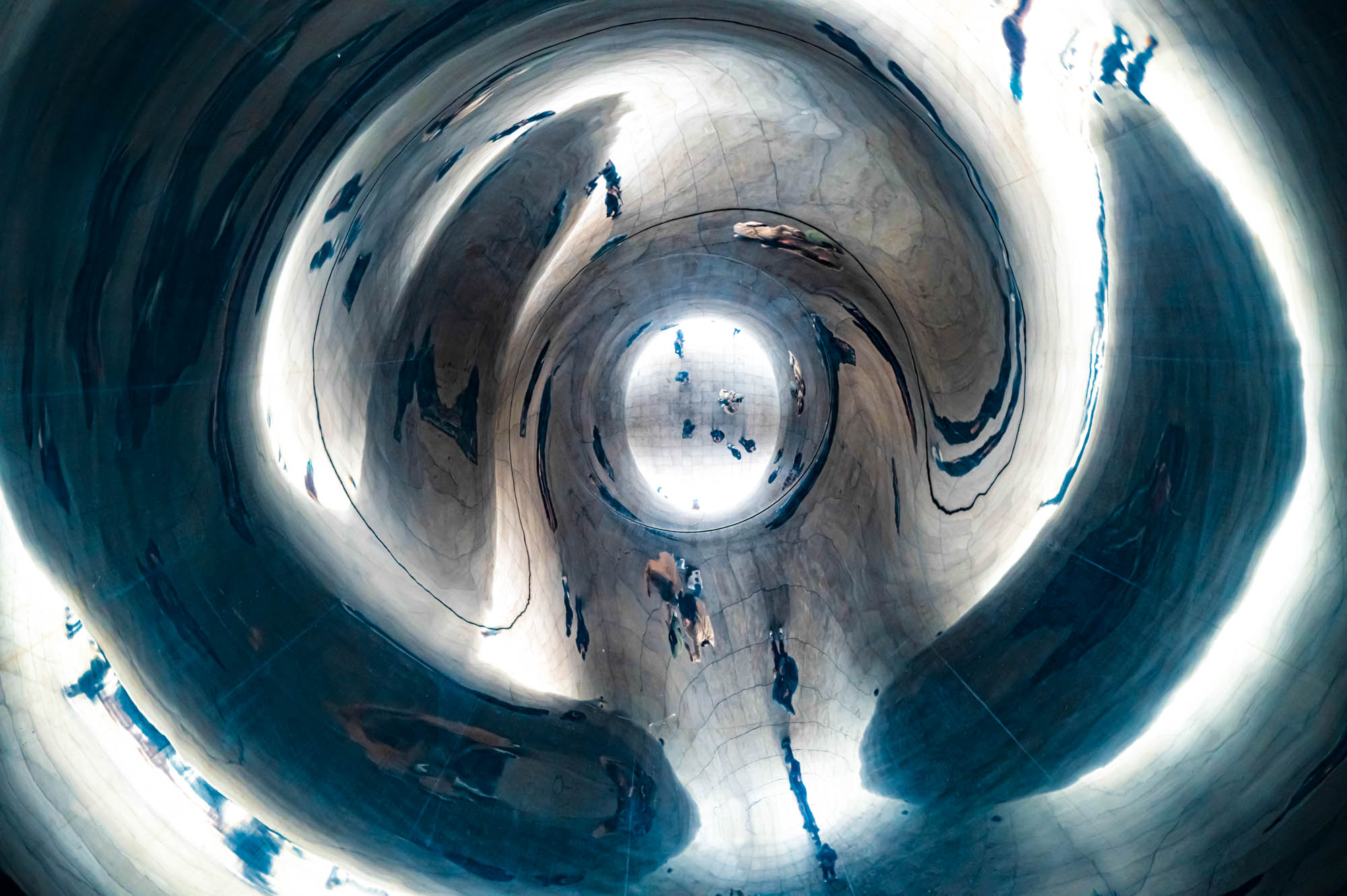 Abstract steel structure with reflections creating a vortex effect, reminiscent of a futuristic tunnel.