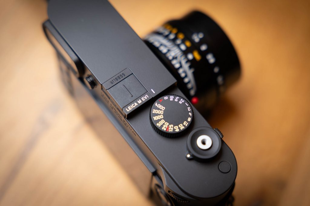 Close-up of a Leica M film camera, showcasing the shutter speed dial and manual controls.