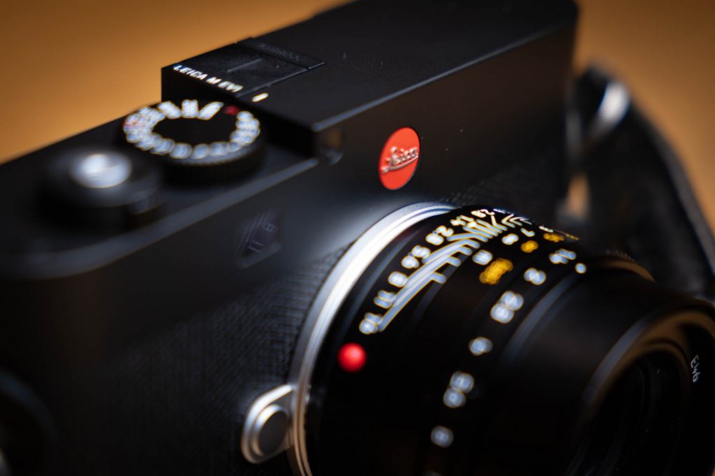 Close-up of black Leica camera with detailed lens and dials, showcasing premium design and precision engineering.